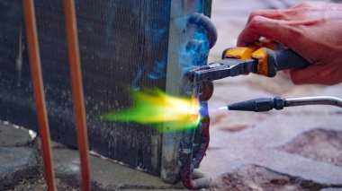 Endüstriyel sistem işçileri bakır boru klima eklemleri ve klima tesisatında bakır tüp büzüşmesi. Klima yoğunlaştırıcı bant sızdırıyor..