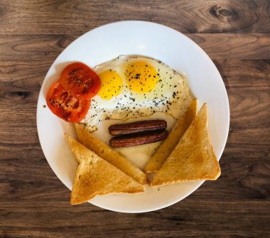 Tabakta kızarmış yumurta, tost ve sosis ile birlikte Amerikan kahvaltısının genel manzarası.