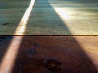 Güneşin gölgeleri olan tahta masa.