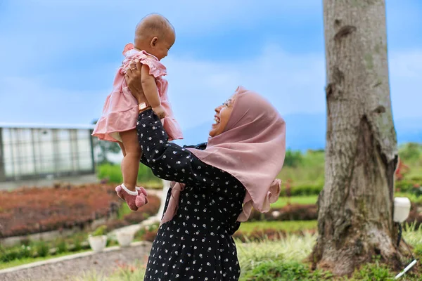 Sevimli ve güzel Asyalı Müslüman bir kadının portresi. Sevgiyle sarılmış ve kaldırılmış bir tesettürlü..