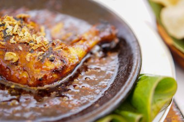 Yakın plan ızgara tavuk ve kobek üzerinde servis edilen baharatlı sambal..