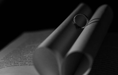 Açık kitap üzerindeki seçici odaklanma kalp şeklinde bir gölgeyle sonuçlanır. Romantik. Aşkın sembolü.