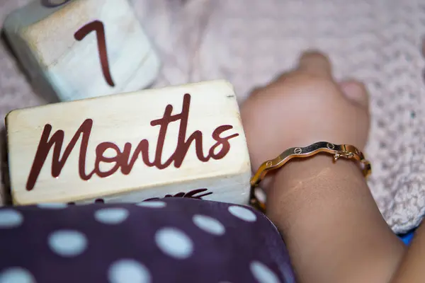 Tahta bir küpün üzerine yazılmış 7 aylık bir bebek.