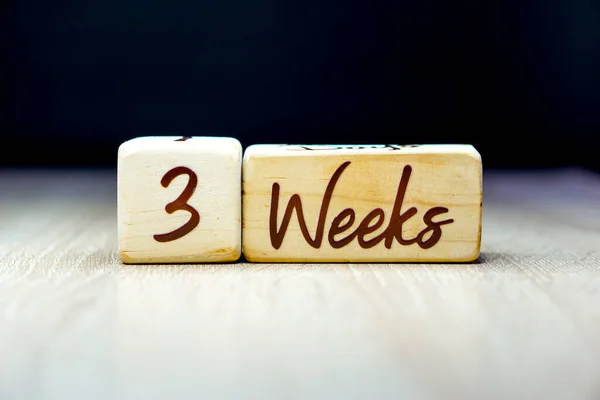 Siyah arka planı olan tahta bir küpte 3 haftalık hamilelik yaşı dönüm noktası.