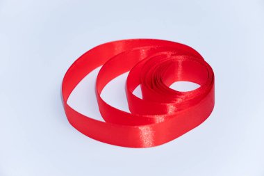 Beyaz arkaplanda izole edilmiş kırmızı kurdele rulosu