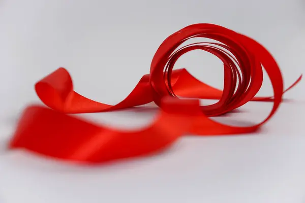 Beyaz arkaplanda izole edilmiş kırmızı kurdele rulosu