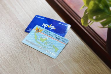 Subang, West Java - Endonezya, 24 Şubat 2024: Ahşap masadaki NPWP kartı veya Vergi Numarası kartı ve KTP (Endonezya Kimlik Kartı)
