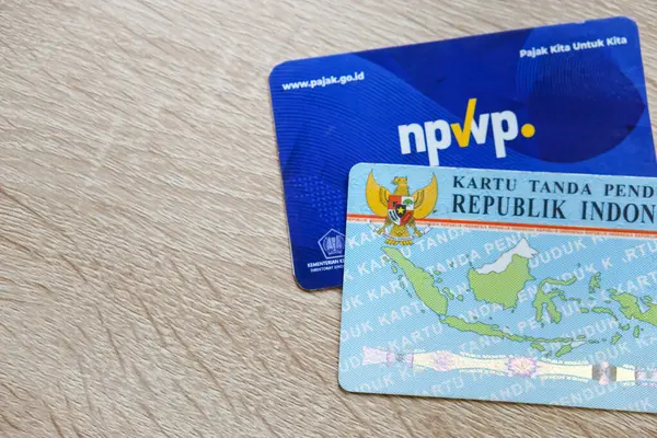 Subang, West Java - Endonezya, 24 Şubat 2024: Ahşap masadaki NPWP kartı veya Vergi Numarası kartı ve KTP (Endonezya Kimlik Kartı)