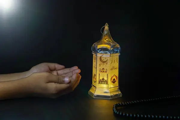 Ramadan Kareem, Muslim praying hands with black background and lantern lights