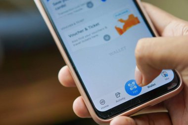 Çevrimiçi ödeme yapmak için akıllı telefon tutan bir adam.