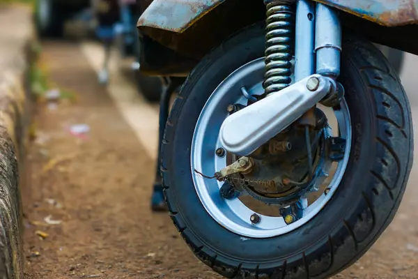 Klasik bir motosiklet ön tekerleğinin portresi sokağa park edilmiş.