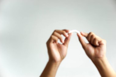 Odaklanamayan bir adamın eli sigarayı yok etmeye çalışır. Beyazlara izole edilmiş, sigara içme konsepti, Dünya Tütünsüz Günü.