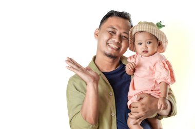 Sevimli bebeğini sevimli bir şapkanın içinde tutan mutlu bir baba. İkisi de sıcak bir şekilde gülümsüyor, sevgi dolu bir aile anı sergiliyorlar..