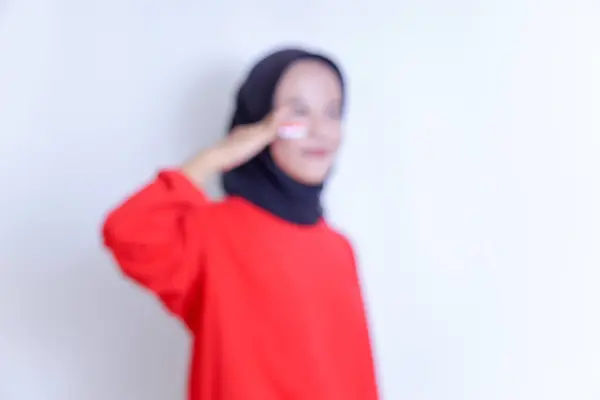 Endonezyalı genç bir kadının tesettüre ve yanaklarına Endonezya bayrağı çizilmişti. Kırmızı tepeli, açık arkaplanda gülümsüyordu..