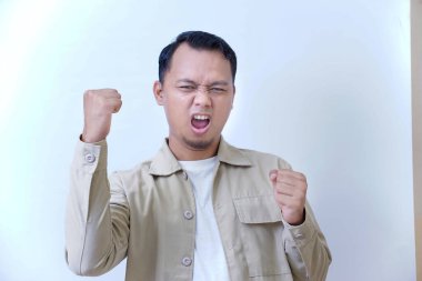 Heyecan ve kararlılığını yumruklarıyla ve sert bakışlarıyla ifade eden bir adam..