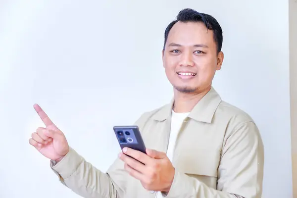 Elinde akıllı bir telefon tutan, gülümseyen ve yukarıyı gösteren, pozitiflik taşıyan bir adam..