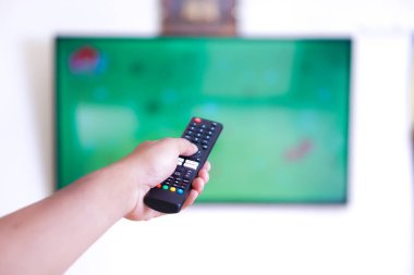 Uzaktan kumandalı bir el televizyonu hedef alıyor.