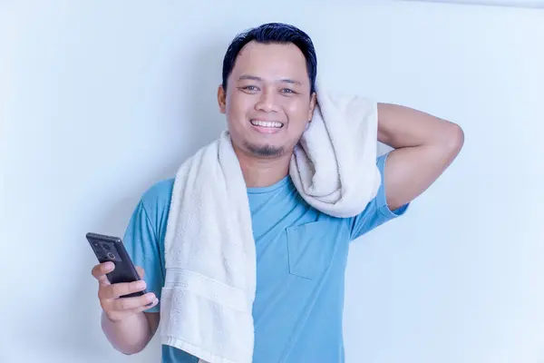 Telefonunu kontrol ederken gülümseyen Asyalı bir adam mutluluk ve rahatlama yayıyor..