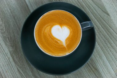 Üzerinde kalp tasarımı olan sıcak bir fincan kahve. Her kahve aşığı için mükemmel..