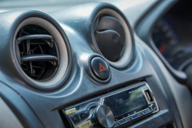 Close-up of a car dashboard featuring air vents and a hazard button for safety. clipart