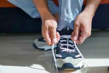 Ayakkabı bağcıklarını bağlayan biri, önümüzde aktif bir güne hazırlanıyor..