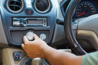 Sürücü sürücü sürücü koltuğunda otururken klimayı ayarlar.