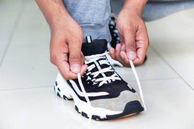 Ayakkabı bağcıklarını bağlayan biri, önümüzde aktif bir güne hazırlanıyor..