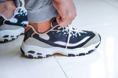 Ayakkabı bağcıklarını bağlayan biri, önümüzde aktif bir güne hazırlanıyor..