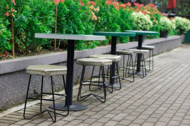 Stylish outdoor seating arrangement surrounded by vibrant greenery. clipart