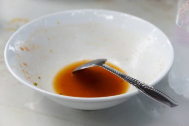 Neredeyse boş bir kase, arta kalan sos ve bir kaşık, bitmiş bir yemeği gösteriyor..