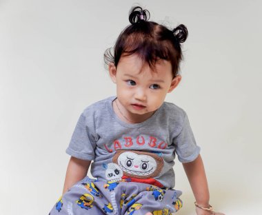 SuBANG-IDNONESYA, HAZİRAN 12025, renkli gömlek giyen sevimli Asyalı kız neşeli bir ifade sergiliyor