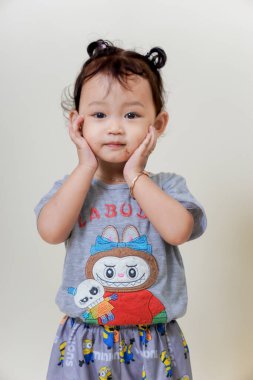 SuBANG-IDNONESYA, HAZİRAN 12025, renkli gömlek giyen sevimli Asyalı kız neşeli bir ifade sergiliyor