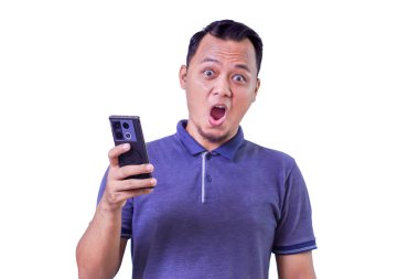 Şaşırmış Asyalı bir adam akıllı telefon tutuyor, ağzı açık şok ya da heyecan ifade ediyor.