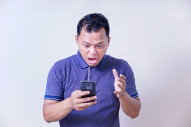 Sinirli Asyalı adam telefonunu kontrol ediyor. Stres ya da rahatsızlık veriyor..