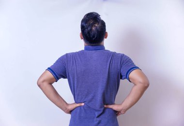 Bir adamın arka görünüşü elleri kalçasında duruyor, özgüven ve tefekkür gösteriyor..