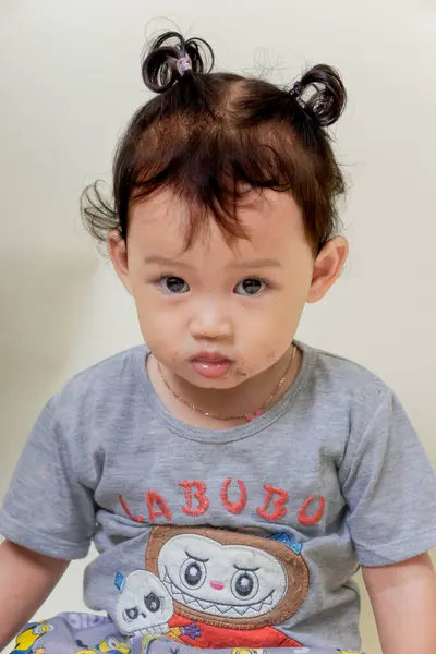 SuBANG-IDNONESYA, HAZİRAN 12025, renkli gömlek giyen sevimli Asyalı kız neşeli bir ifade sergiliyor