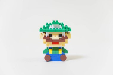 SuBANG-IDNONESIA, HAZİRAN 12025, yeşil şapkalı neşeli bir karakteri andıran neşeli bir tuğla figürü