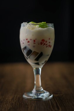 İçinde krema ve renkli malzemeler olan lezzetli bir tatlı içeceği.