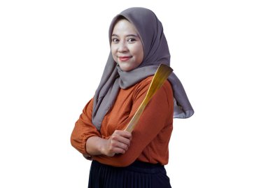 Kolları çaprazlanmış gülümseyen, tahta bir spatula tutan, beyaz arka planda izole edilmiş pişirmeye hazır kendinden emin Asyalı kadın.