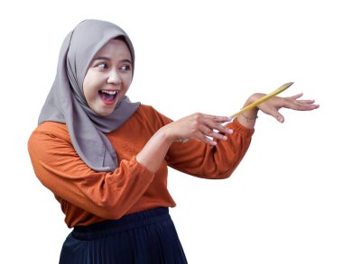 Tesettürlü neşeli bir Asyalı kadın spatulayla şakacı hareketler yapar, beyaz arka planda izole edilmiş, coşkulu bir görüntü sergiler..