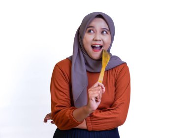 Tesettürlü neşeli bir Asyalı kadın elinde bir kaşıkla, canlı enerji ve neşe saçıyor, beyaz bir karavanda izole edilmiş..