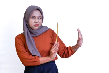 Tesettürlü bir kadın elinde spagetti tutarken ve el kol hareketleriyle durmaya çalışırken tiksinmiş görünür..