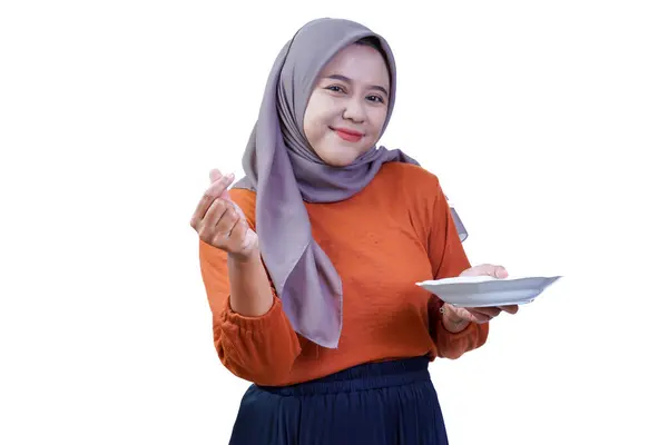 Tesettürlü gülümseyen Asyalı kadın, bir tabağı tutarken kalp hareketi yapıyor, sevgi ve sıcaklığı gösteriyor..