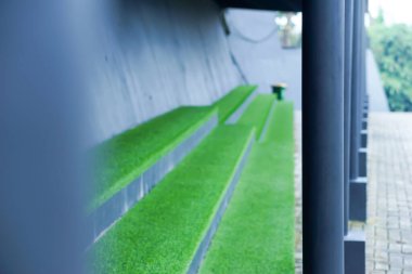 Canlı yeşil çimenler ve modern tasarım elementleriyle gösterişli bir oturma yeri..