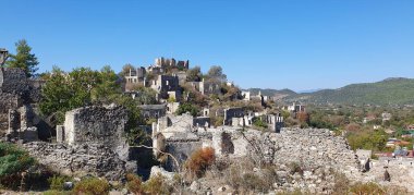 Kayakoy hayalet kasabası, terk edilmiş eski Yunan köyü. Tepenin güzel yeşil yamacındaki antik şehir manzarası