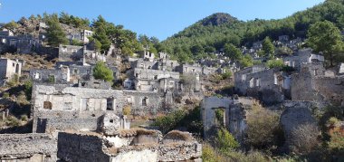 Kayakoy hayalet kasabası, terk edilmiş eski Yunan köyü. Tepenin güzel yeşil yamacındaki antik şehir manzarası