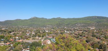 Türkiye 'nin Mugla ilçesine bağlı Fethiye yakınlarındaki terk edilmiş Kayakoy (Levissi) köyünde kalenin manzaralı yeni yerleşim yeri