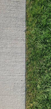 Yeşil çimen deseni ve çimento asfalt arka plan dokusu. Yakın plan. Arkaplan.