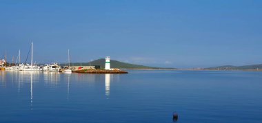 Beach and lighthouse in Ayvalik clipart