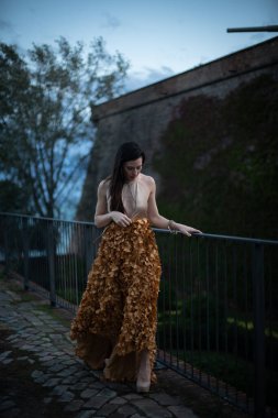 İspanyol kalesinin önünde poz veren zarif bir elbise giymiş bir kadın..